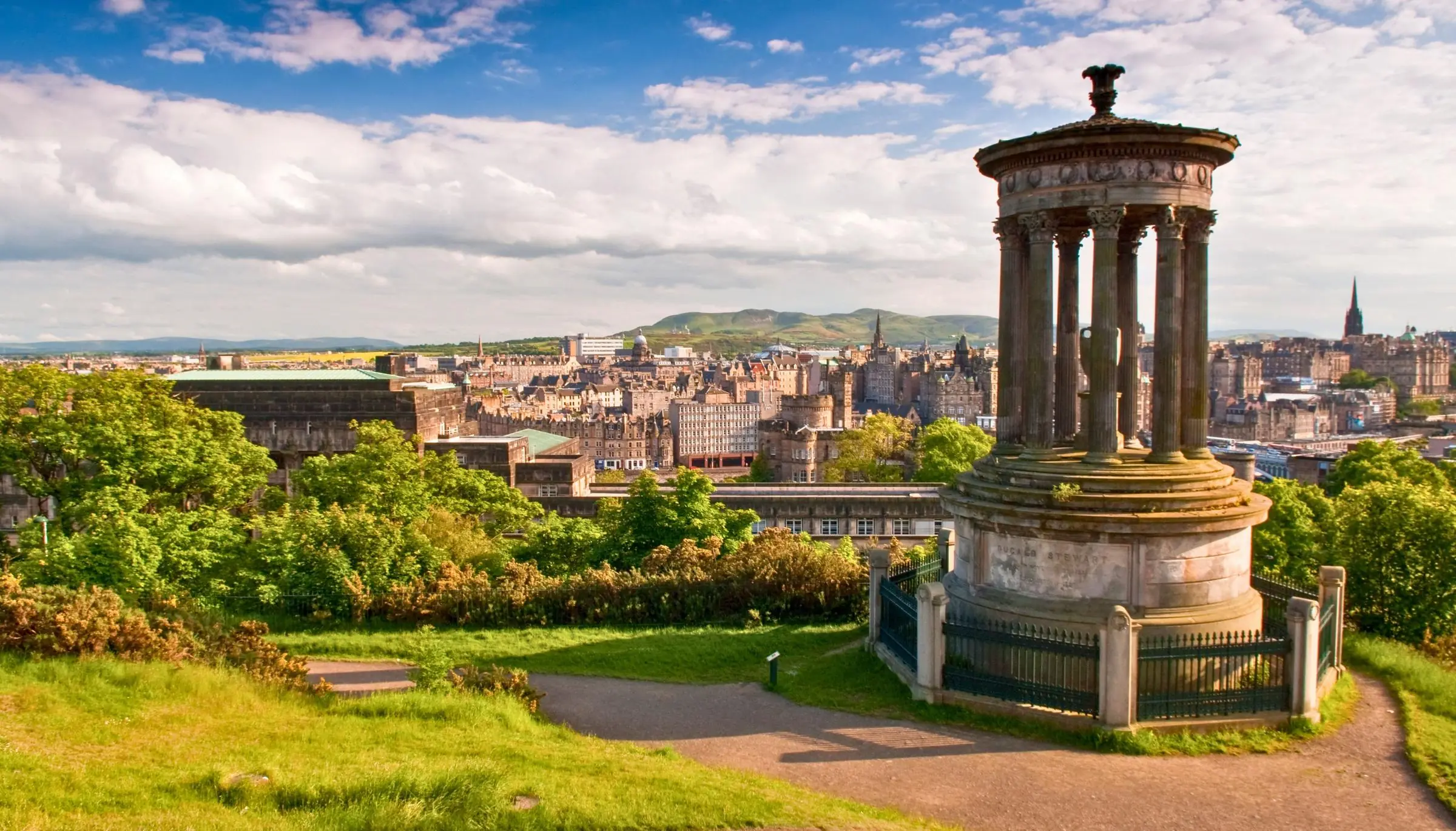 The Dugald Stewart Monument on Calton Hill with the Edinburgh skyline in the background at sunset